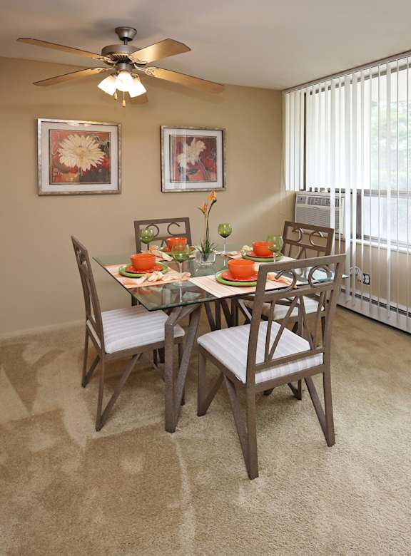 A dining room with a table set for four.