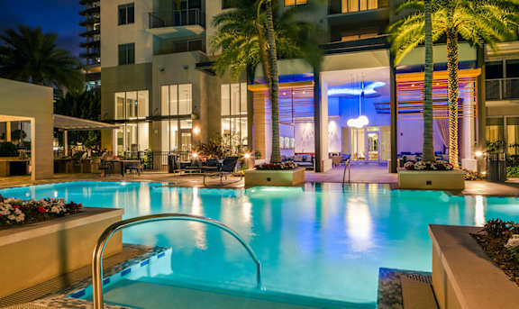 A swimming pool in a residential area at night.