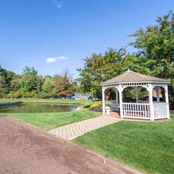 a gazebo on the side of a pond