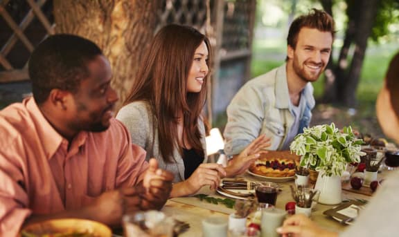 a group of people sitting around a table eating food
