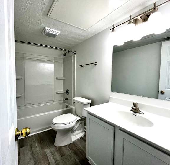 A white toilet is in a small bathroom with a white sink.