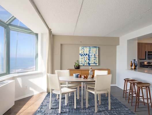 A dining room with a table and chairs. at 10 West Apartments, Long Beach, New York