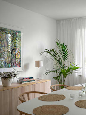 A dining room with a white table and chairs.