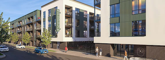 A street view of a modern building with cars parked on the side of the road.