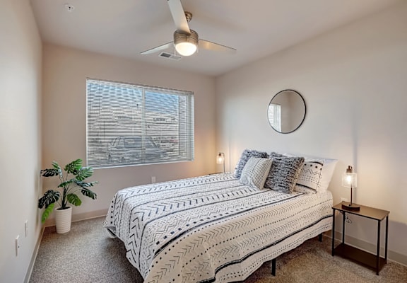 a bedroom with a bed and a ceiling fan
