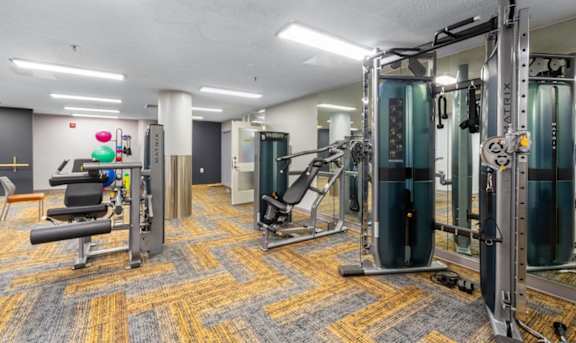 a gym with weights and cardio equipment in a building at Mill House Apartments, Greenfield, MA