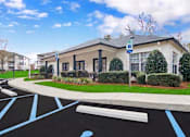 Thumbnail 1 of 19 - A parking lot with a handicap parking sign in front of a building.