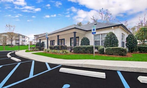 A parking lot with a handicap parking sign in front of a building.