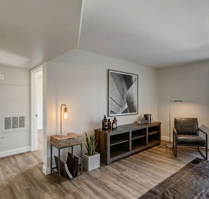 A room with a chair, a table, and a painting on the wall.
