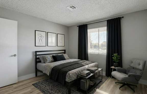 Living room with gray sofa and large window at Playa Vista Apartments, Las Vegas, NV 89110