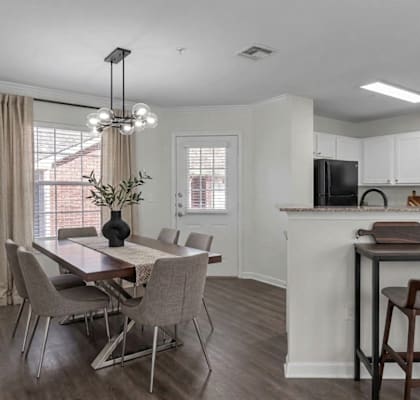 A kitchen with a dining table and chairs.