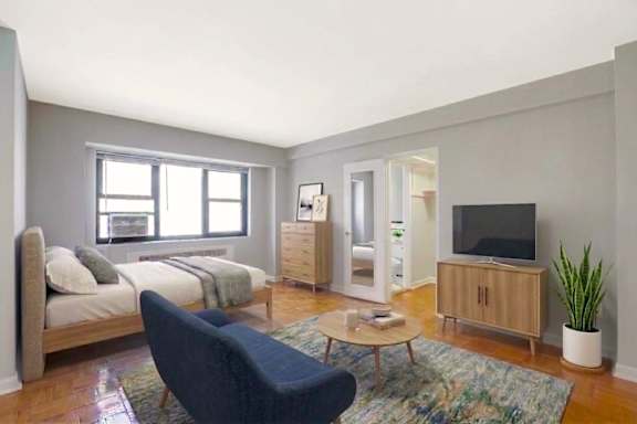A bedroom with a bed, a chair, a coffee table, and a television.