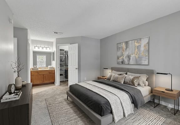 A bedroom with a large bed and a painting on the wall.