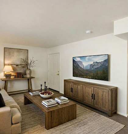 A living room with a couch, a coffee table, and a painting on the wall.