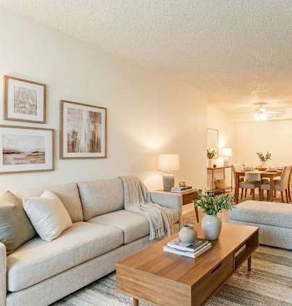 A living room with a couch, coffee table, and pictures on the wall.