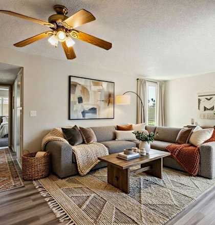 A living room with a grey couch and a wooden coffee table.