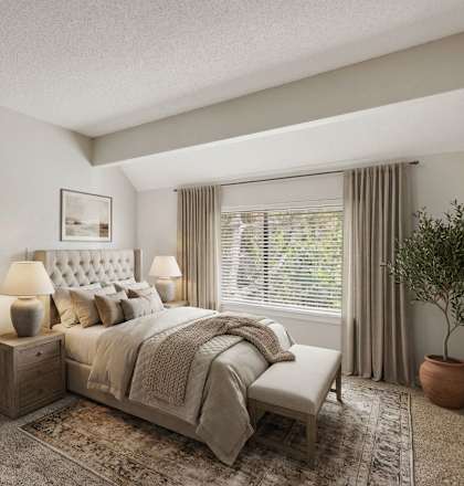 A bedroom with a large bed and a dressing table with a mirror.