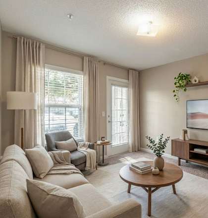 A living room with a large couch, a coffee table, and a painting on the wall.