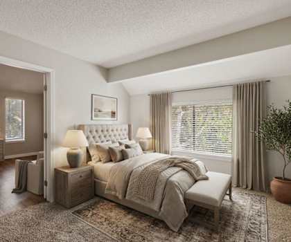 A bedroom with a large bed and a dressing table with a mirror.