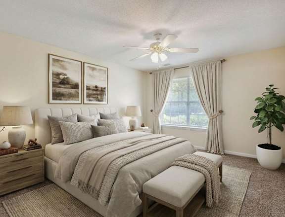 A bedroom with a large bed, a ceiling fan, and a potted plant.