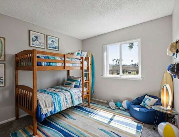 A room with two bunk beds and a blue bean bag chair.