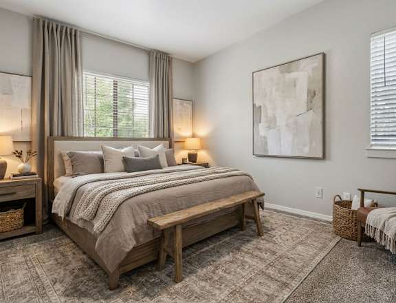 A bedroom with a large bed and a bench.