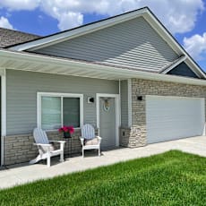 A house with a grey roof and a white garage door.