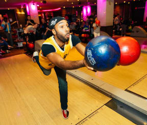a man holding a bowling ball in a bowling alley