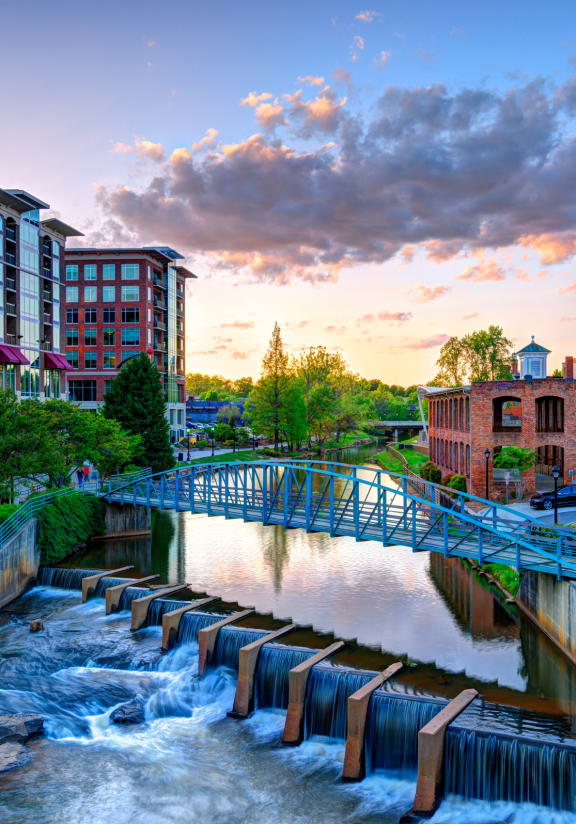 a bridge over a river with a waterfall in a city