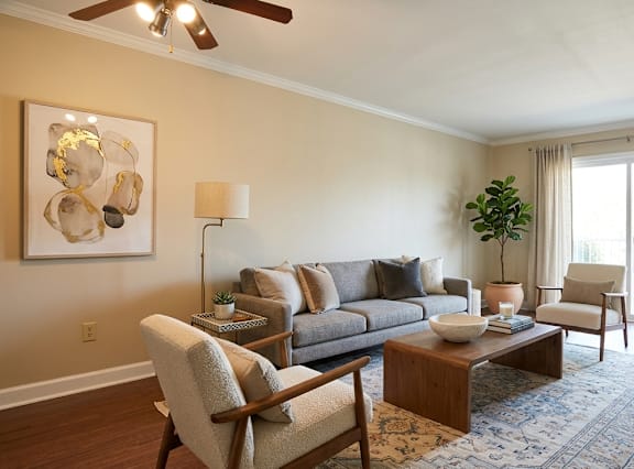 A living room with a couch, chair, and a painting on the wall.