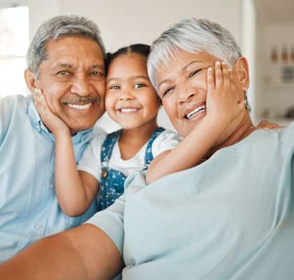 A family of three, two adults and a child, are taking a selfie together.