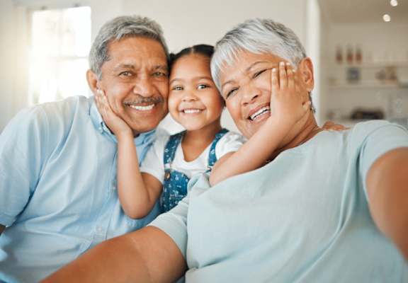 A family of three, two adults and a child, are taking a selfie together.