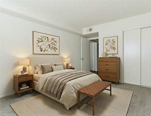 A bedroom with a bed, nightstand, and wardrobe.