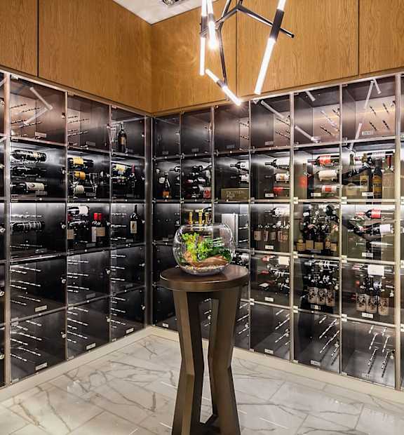 A wine cellar with a table in front of it. at Two Lincoln Tower Apartments, Bellevue, WA, 98004