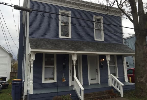 a blue house with white trim and a gray roof