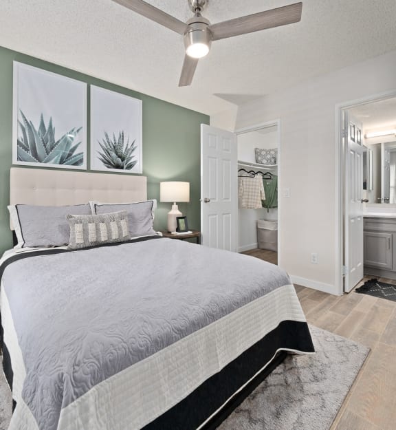 a bedroom with a bed and a bathroom with a plant