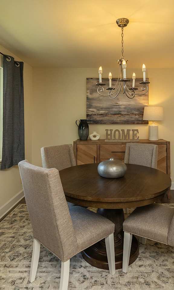 A dining room with a round table and chairs.