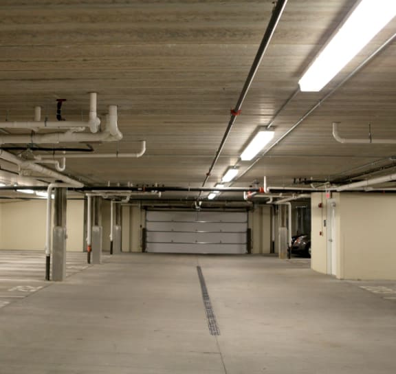 the inside of a building with a long hallway and garage doors
