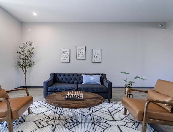 a living room with a blue couch and two brown chairs