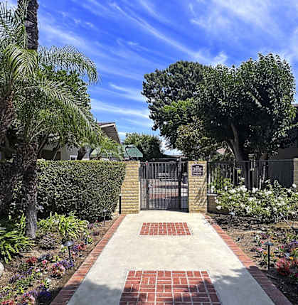 A garden with a brick pathway leading to a gate.