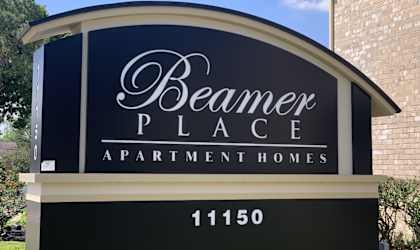 a sign for beaver place apartment homes in front of a brick building