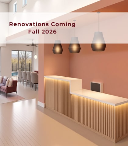 A modern living room with a reception desk and a view of the outdoors.