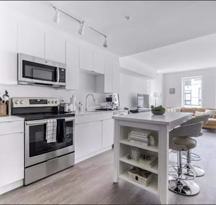 a kitchen with a white counter top next to a stove top oven
