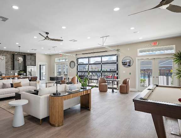 A well-lit room with a pool table and a bar area.
