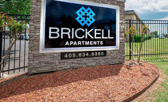 A sign for Brickell Apartments is displayed in front of a building.