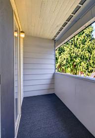 A balcony with a view of a building and trees.
