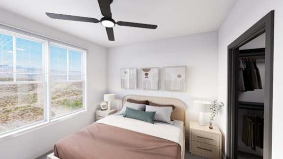 A bedroom with a bed, a ceiling fan, and a window overlooking a landscape. at Refinery at Pointe17 Apartments, Phoenix, AZ, 85085