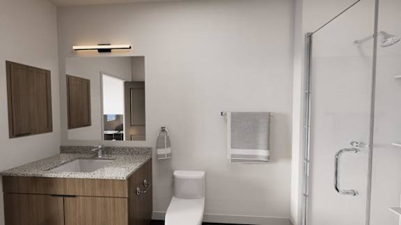 A bathroom with a toilet, sink, mirror, and shower. at The Logan Luxury Apartments, Idaho, 83651