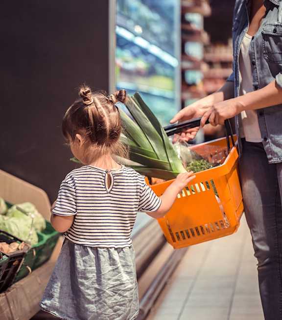 A woman and a girl are shopping for vegetables.