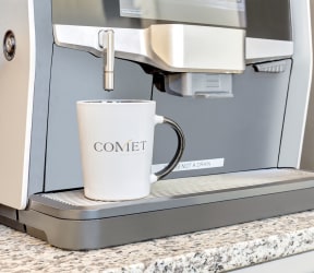 a coffee mug sitting in a coffee maker on a counter